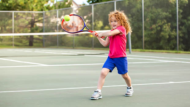 Young Girl Practicing Playing Tennis